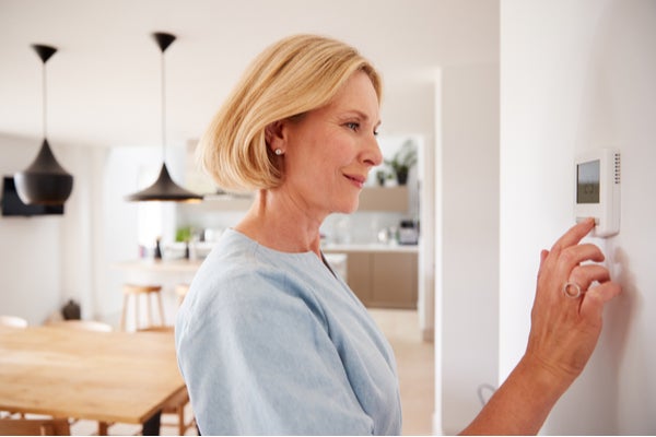 Women adjusting a/c unit