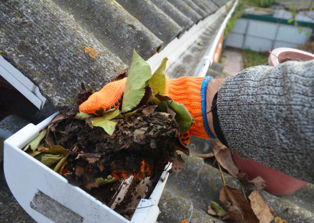 Homeowner cleaning out gutters