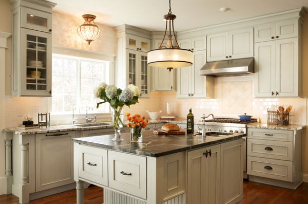 Large single pendant light above a small kitchen counter looks like a modern chandelier