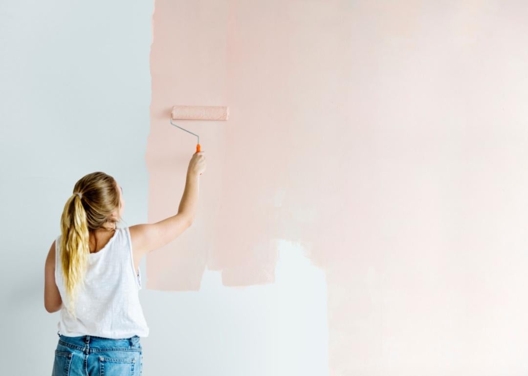 Women painting walls pink