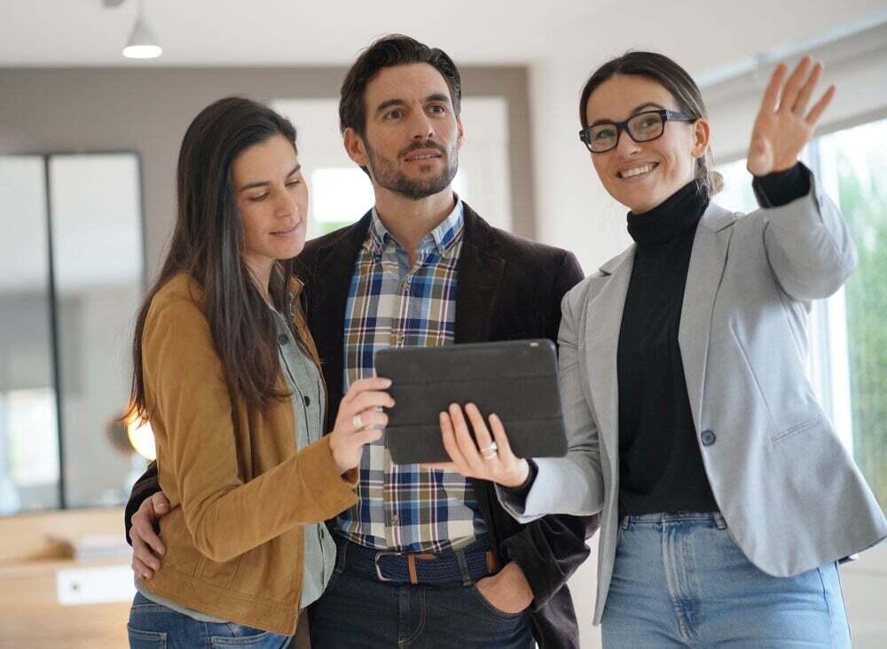 Real estate agent showing a house to two homebuyers.