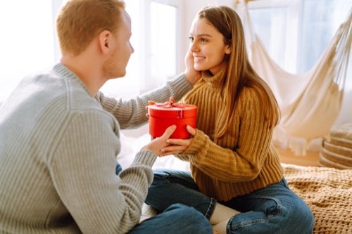 young-couple-sitting-together-holding-a-valentines-day-gift.jpg